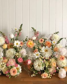 three vases filled with flowers on top of a wooden table