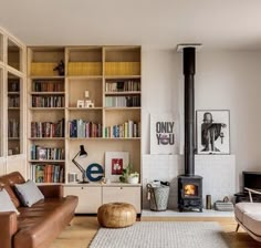 a living room filled with furniture and bookshelves next to a fire burning place