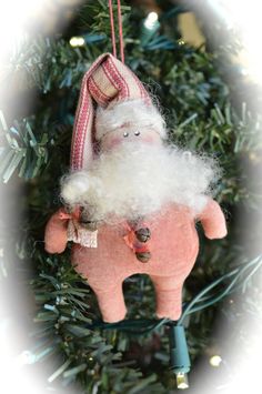 a santa clause ornament hanging from a christmas tree