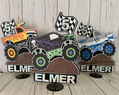 two wooden signs with monster trucks on them, one is for elmer and the other is for firetrucks