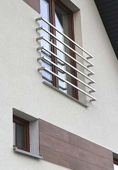 a clock on the side of a building with wooden shutters and window sill