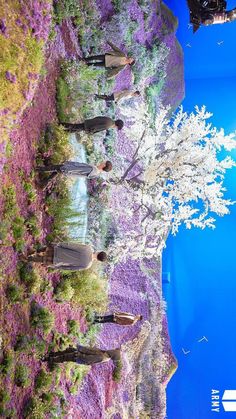 people are standing in front of purple flowers