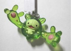 a green keychain with a cartoon character on it's face and hands