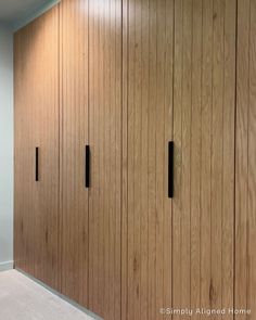 an empty room with wooden closets and carpeted flooring in the middle of it