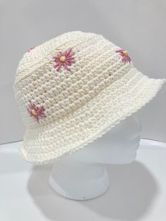 a white crocheted hat with pink flowers on it