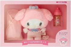 a hello kitty doll in a pink box next to a baby's pacifier