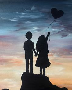 a couple holding hands while standing on top of a hill with a heart shaped balloon