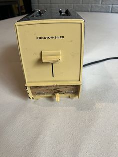 an old yellow projector sitting on top of a white table