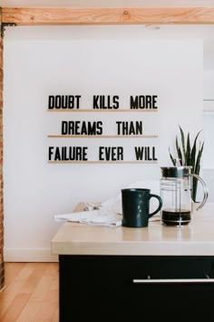 a coffee mug sitting on top of a counter next to a sign that says doubt kills more dreams than failure ever will