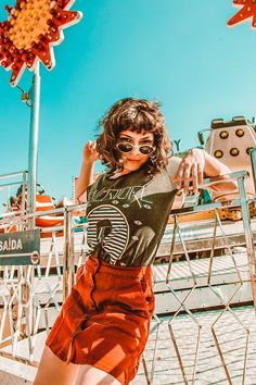 a woman posing for the camera in front of an amusement park