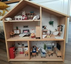 a wooden doll house with furniture and accessories