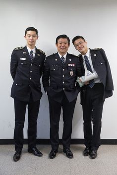 three men in uniform standing next to each other