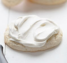 a cookie with white icing next to some cookies