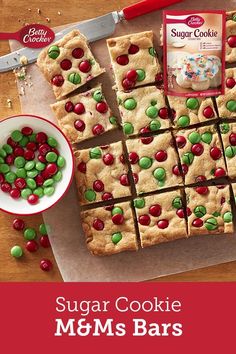 sugar cookie m & ms bars are cut into squares and placed on a cutting board