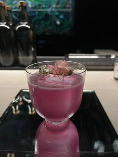 a pink drink sitting on top of a glass table