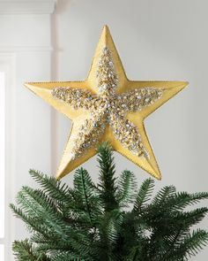 a gold star decoration on top of a christmas tree