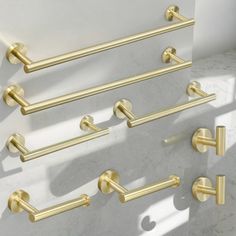 four brass bathroom hardware on a white wall