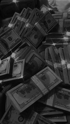 a pile of money sitting on top of a table next to each other in black and white