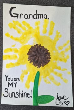 a handprinted sunflower with the words grandma you are my sunshine on it