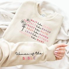 a woman's hands holding a white shirt with the words women of the bible printed on it