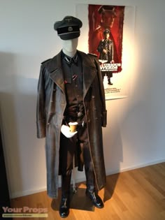 a costume is displayed in front of a movie poster and an image on the wall