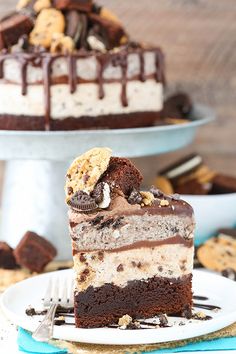 a piece of cake on a plate with a fork and some cookies in the background