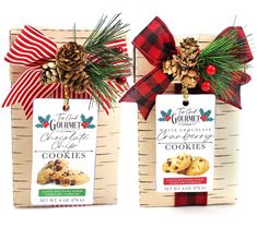 two packages of cookies tied to wooden boards with bows and pine cones on the top