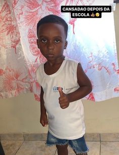 a young boy is giving the thumbs up sign