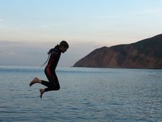 a person jumping into the air over water