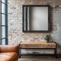 a living room with a couch, table and mirror on the brick wall behind it