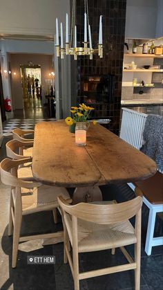 a wooden table with chairs around it and a vase full of flowers on the table