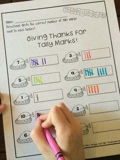 a person holding a pencil and writing on a sheet of paper with the words giving thanks for