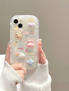 a person holding up a phone case with stickers on it