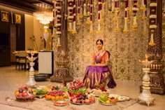 a woman sitting on the floor surrounded by food