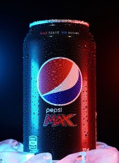 a can of pepsi max sitting on top of ice cubes in front of a black background