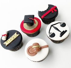 four decorated cupcakes with graduation decorations on the top one has a ring and two are chocolate