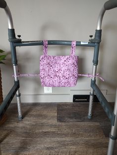 a pink bag hanging from the side of a metal frame