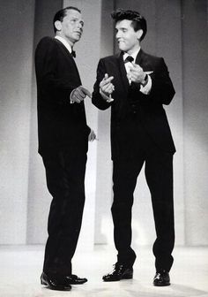 two men in tuxedos are standing next to each other and one is holding his hand out