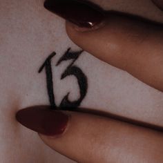 a woman's hand with a tattoo that has the number fifteen on it and an arrow