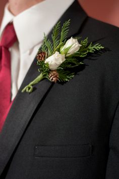 a man wearing a suit and tie with a boutonniere on his lapel