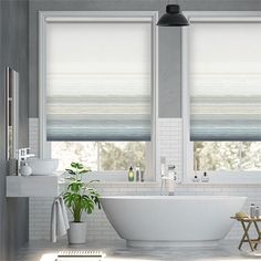 a white bath tub sitting under two windows