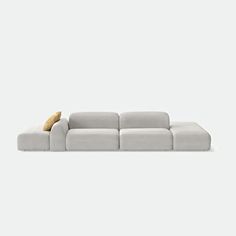 a gray couch with a yellow pillow on the back and white walls in the background