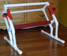 a white and red soccer goal sitting on top of a wooden floor next to a dresser