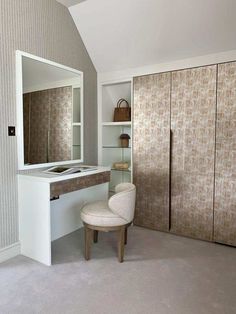 a white chair sitting in front of a mirror on top of a cabinet next to a counter