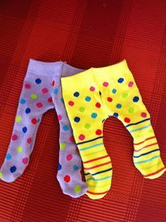 two pairs of baby leggings with colorful polka dots on them sitting on a red surface