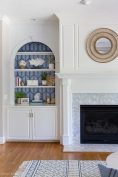 a living room filled with furniture and a fire place in front of a white fireplace