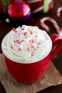 a red cup filled with whipped cream and candy canes on top of a napkin