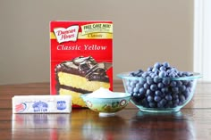 blueberries, cheesecake and milk are on the table next to two packages of cheesecake