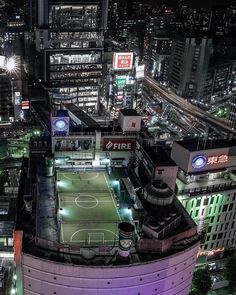 an aerial view of a city at night with lots of lights and buildings in the background