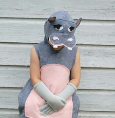 a child in a hippopotamus costume standing with his hands on his hips